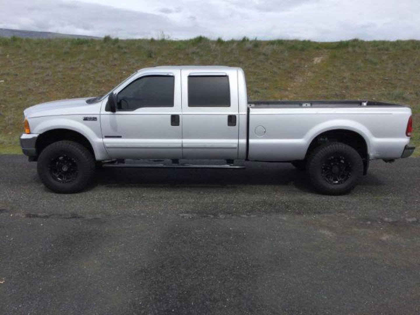 2001 Silver Clearcoat Metallic /Black Leather Ford F-250 XLT Crew Cab Long Bed 4WD (1FTNW21F11E) with an Powerstroke 7.3L V-8 diesel direct injection engine, 4 speed automatic transmission, located at 1801 Main Street, Lewiston, 83501, (208) 743-9371, 46.417065, -117.004799 - Photo#1